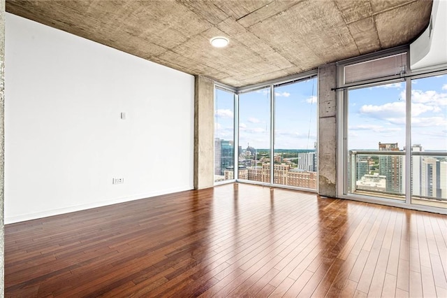 unfurnished room featuring floor to ceiling windows and hardwood / wood-style floors