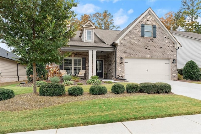 view of front of house with covered porch, a garage, and a front yard