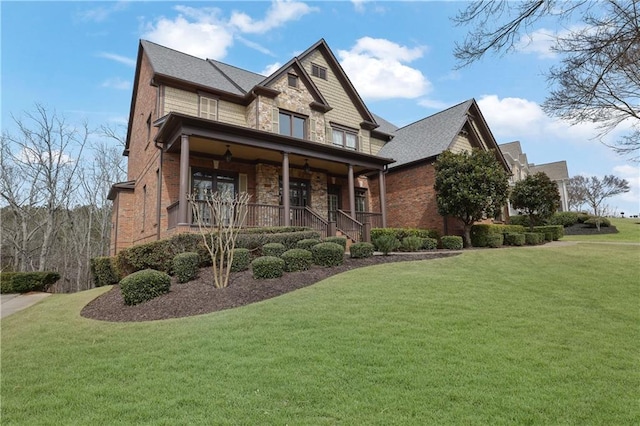 craftsman-style house featuring brick siding, stone siding, covered porch, and a front lawn