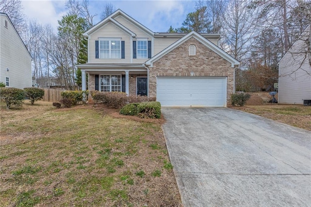 traditional home with an attached garage, brick siding, fence, driveway, and a front yard