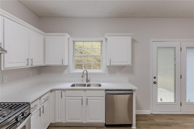 kitchen with a sink, light wood finished floors, white cabinetry, and stainless steel dishwasher