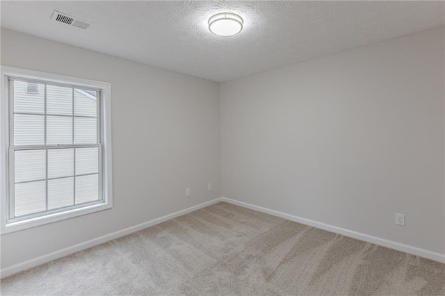 unfurnished room with carpet floors, plenty of natural light, visible vents, and baseboards