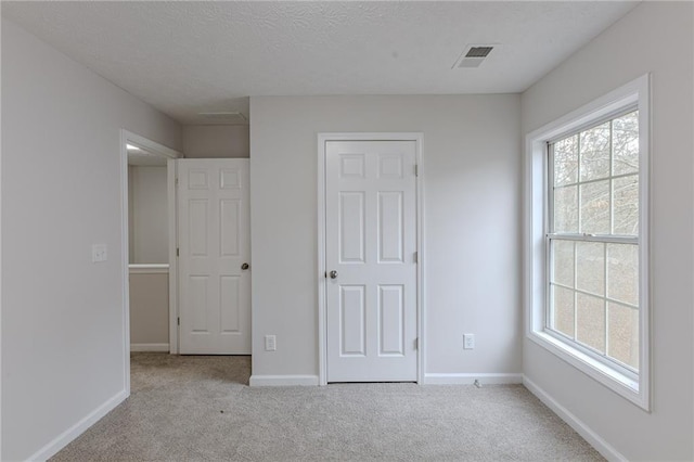 unfurnished bedroom featuring multiple windows, baseboards, and carpet flooring