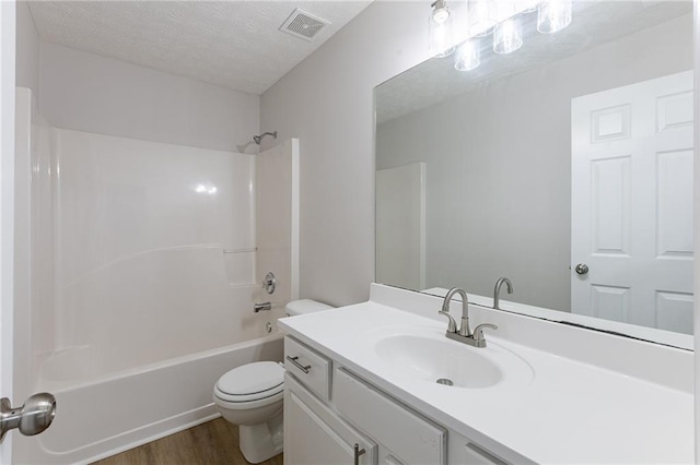 bathroom with bathtub / shower combination, visible vents, toilet, a textured ceiling, and vanity