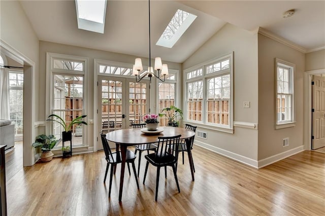 dining area with light wood-type flooring, baseboards, visible vents, and a notable chandelier