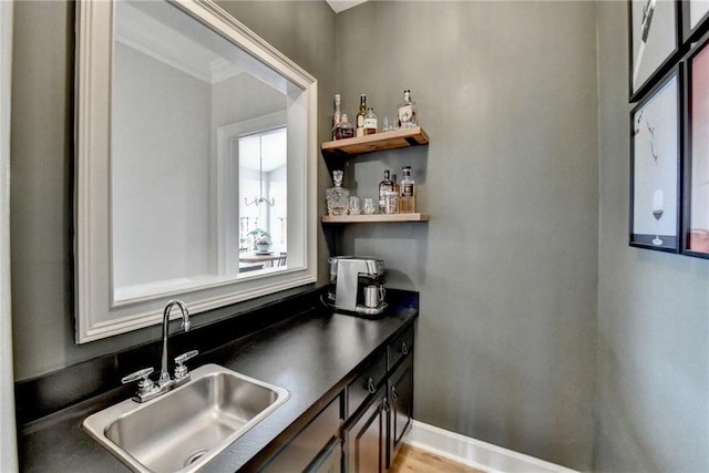 kitchen featuring open shelves, dark countertops, a sink, and baseboards