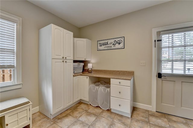 interior space with light countertops, white cabinetry, and baseboards