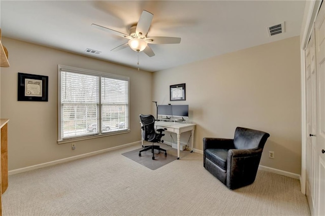 carpeted office space with baseboards, visible vents, and a ceiling fan