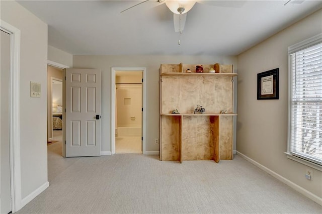 unfurnished bedroom featuring multiple windows, carpet flooring, and baseboards