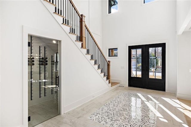 entrance foyer with a wealth of natural light, french doors, and a high ceiling