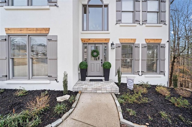 doorway to property featuring stucco siding