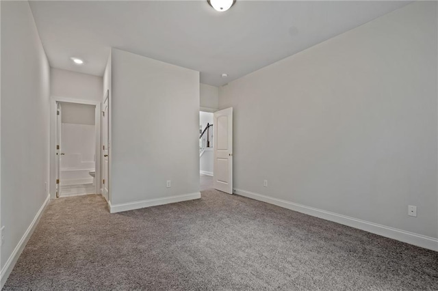 unfurnished bedroom featuring connected bathroom, carpet floors, and baseboards