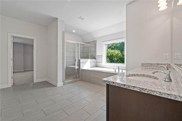full bath with a stall shower, baseboards, a garden tub, vanity, and a spacious closet