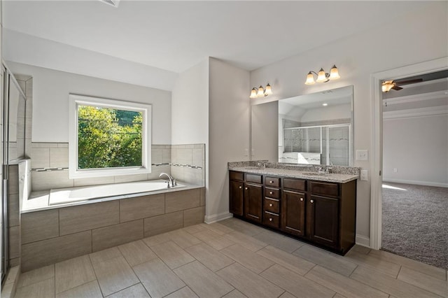bathroom featuring a stall shower, a ceiling fan, a sink, a garden tub, and double vanity