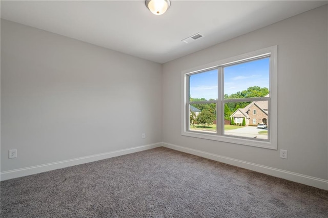 empty room featuring carpet flooring, visible vents, and baseboards