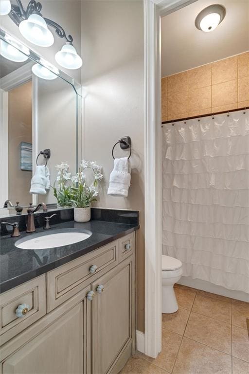 full bath featuring toilet, vanity, and tile patterned flooring