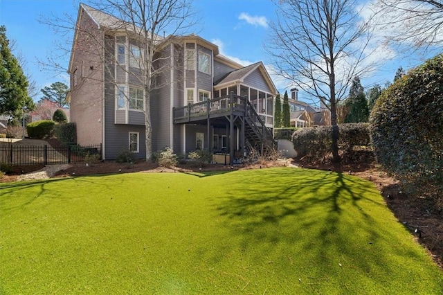 rear view of property featuring stairway, fence, a lawn, and a sunroom