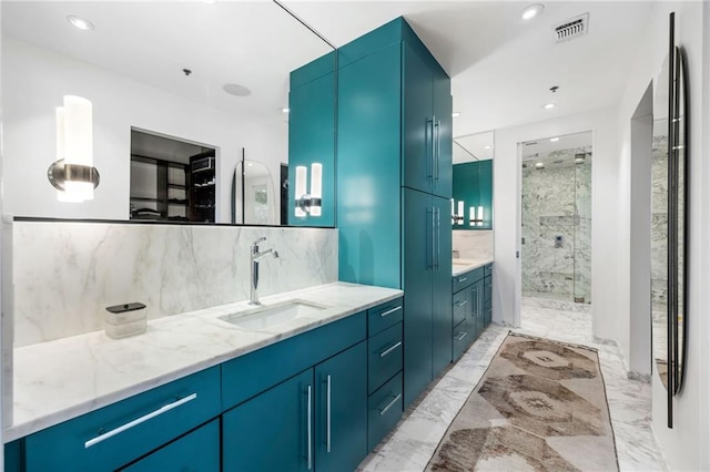 bathroom with marble finish floor, vanity, a shower stall, and visible vents