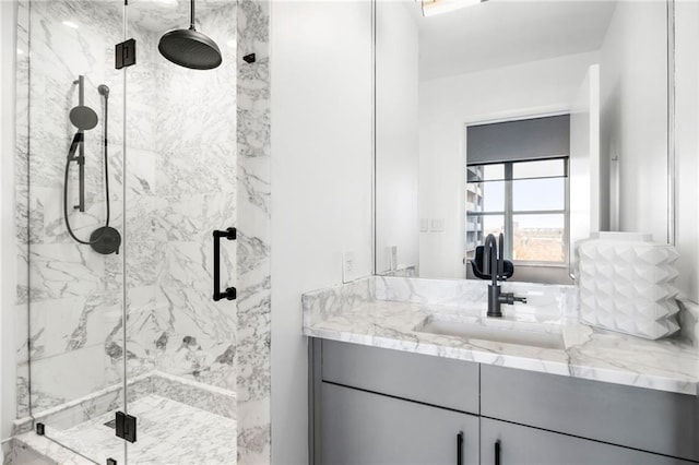 full bath featuring vanity and a marble finish shower