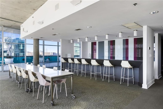 dining area with a wall of windows, visible vents, and baseboards