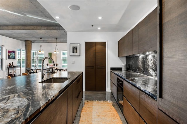 kitchen with dark stone counters, dark brown cabinetry, a sink, and black appliances