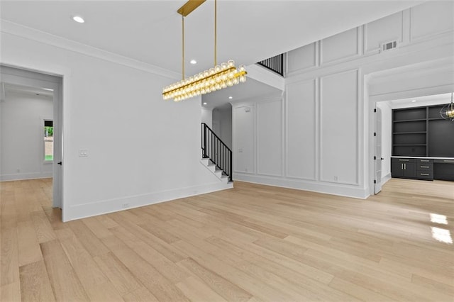 unfurnished living room with visible vents, crown molding, stairway, light wood finished floors, and recessed lighting
