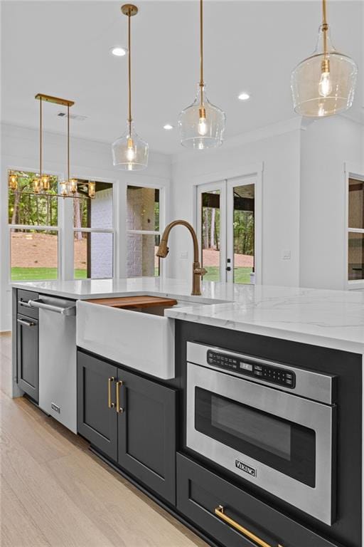 kitchen featuring decorative light fixtures, french doors, appliances with stainless steel finishes, and a sink