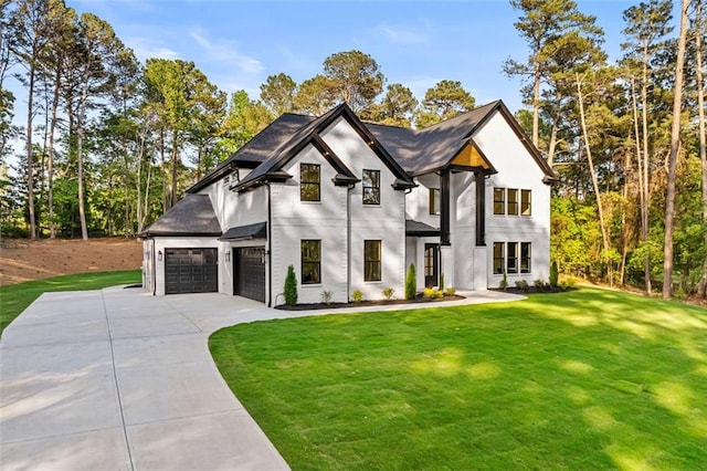 view of front of property featuring a garage, stucco siding, concrete driveway, and a front yard