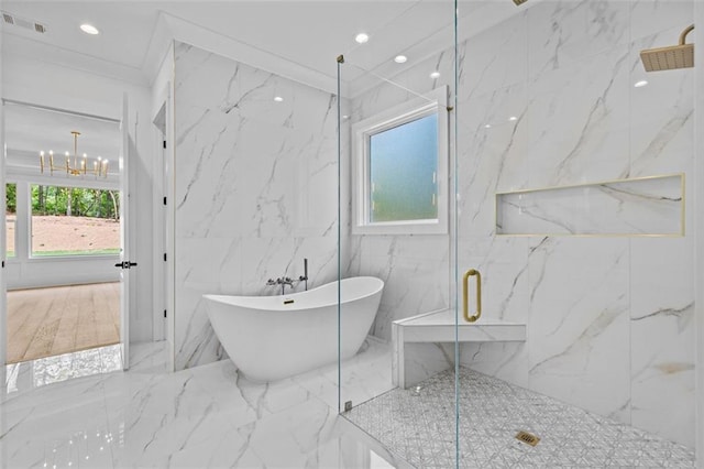 full bath with a freestanding bath, an inviting chandelier, a marble finish shower, marble finish floor, and visible vents