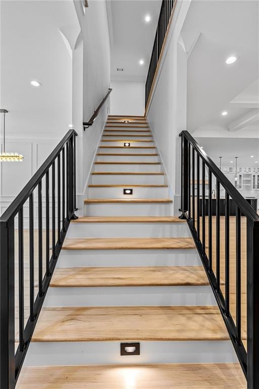 stairs with recessed lighting and a towering ceiling