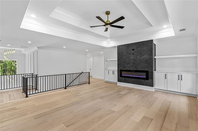 unfurnished living room with a ceiling fan, visible vents, a raised ceiling, light wood-style floors, and recessed lighting