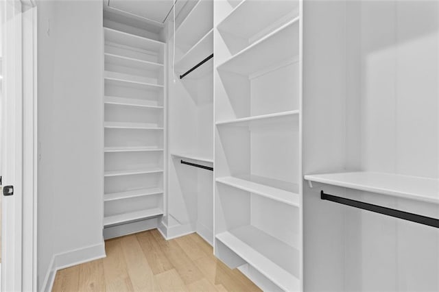 walk in closet with light wood-type flooring