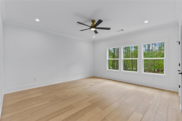 spare room with light wood-style floors, a ceiling fan, baseboards, and ornamental molding