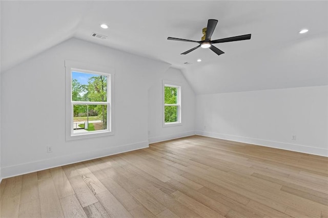 additional living space with visible vents, baseboards, vaulted ceiling, and light wood-type flooring