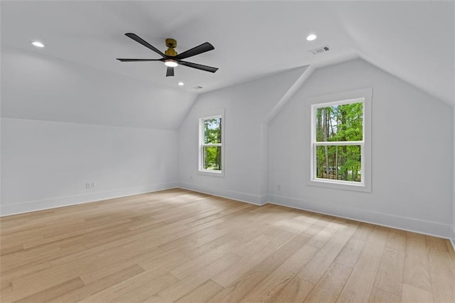 additional living space with visible vents, baseboards, light wood finished floors, and lofted ceiling
