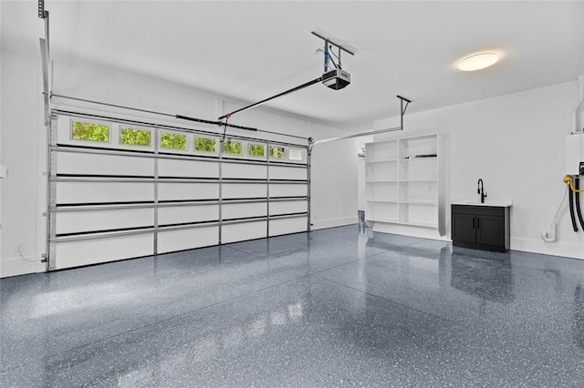 garage with baseboards, a garage door opener, and a sink