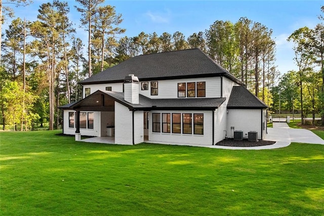 back of house with a patio, a shingled roof, a yard, and cooling unit