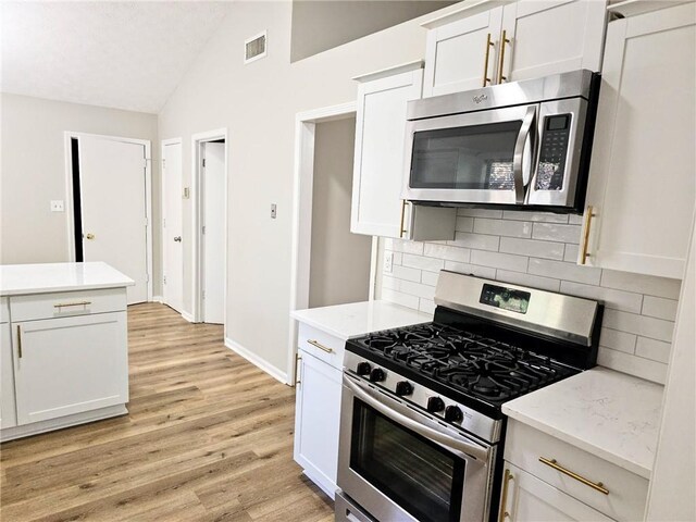 4093 Chapel Mill Bnd, Decatur, GA 30034 - kitchen featuring white cabinetry, lofted ceiling, stainless steel appliances, visible vents, and light wood-style floors