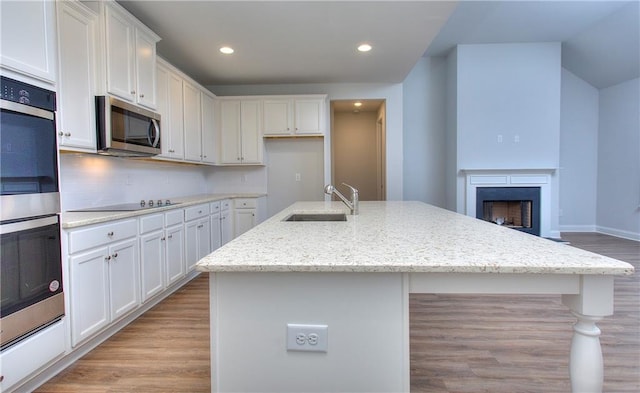135 Applewood Way, Homer, GA 30547 - kitchen with appliances with stainless steel finishes, white cabinetry, an island with sink, sink, and light stone counters