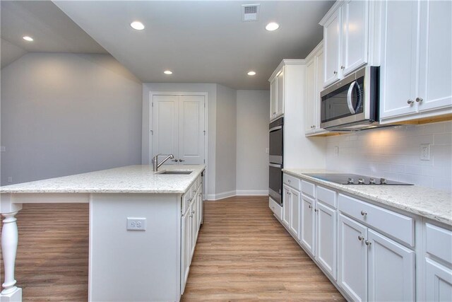 135 Applewood Way, Homer, GA 30547 - kitchen featuring sink, white cabinetry, an island with sink, stainless steel appliances, and light stone countertops