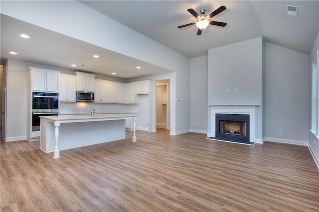 135 Applewood Way, Homer, GA 30547 - kitchen featuring a breakfast bar area, light hardwood / wood-style flooring, white cabinetry, stainless steel appliances, and a center island with sink