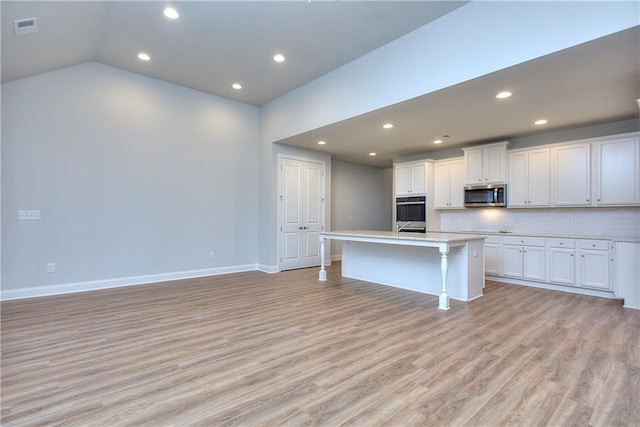 135 Applewood Way, Homer, GA 30547 - kitchen with light hardwood / wood-style floors, stainless steel appliances, an island with sink, and white cabinets