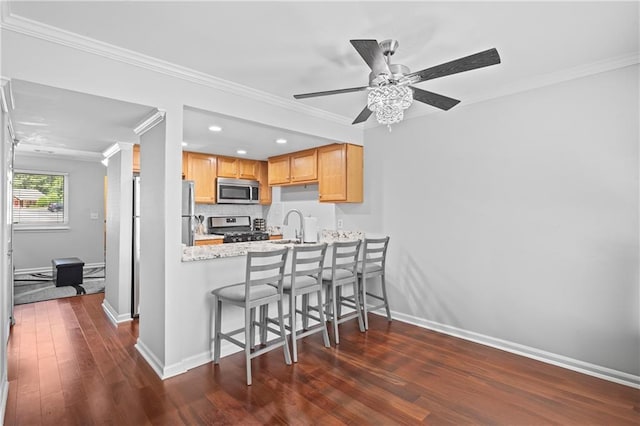 31 Country Place Ct, Alpharetta, GA 30005 - kitchen featuring gas range oven, stainless steel microwave, crown molding, dark wood finished floors, and a kitchen breakfast bar