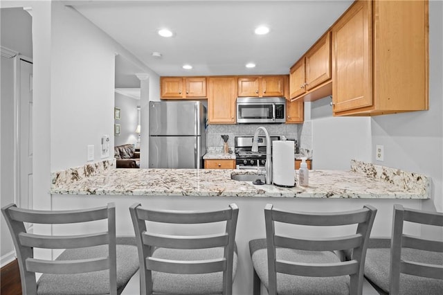 31 Country Place Ct, Alpharetta, GA 30005 - kitchen with stainless steel appliances, a peninsula, tasteful backsplash, recessed lighting, and light stone counters