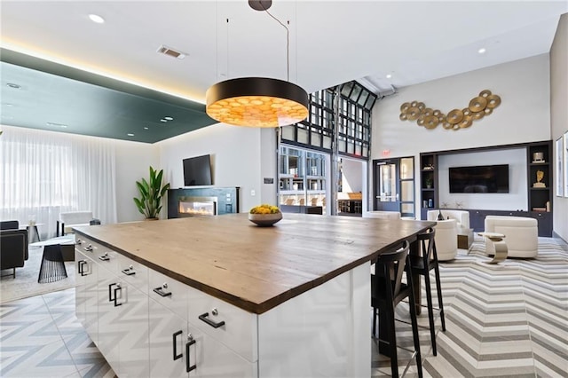 kitchen with butcher block countertops, open floor plan, and visible vents