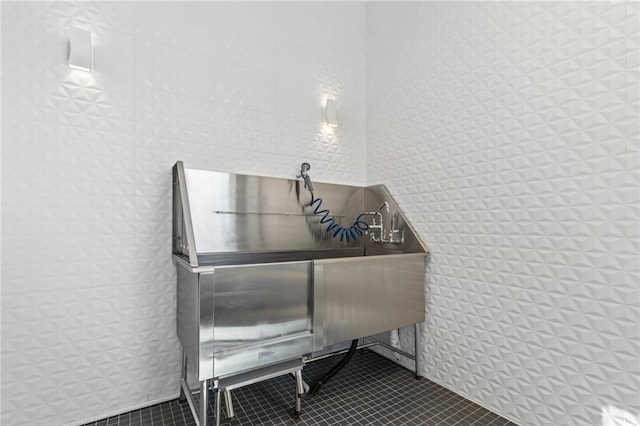 miscellaneous room with a sink, tile patterned flooring, and tile walls