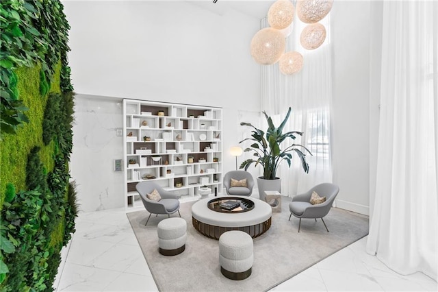 interior space with marble finish floor and a high ceiling