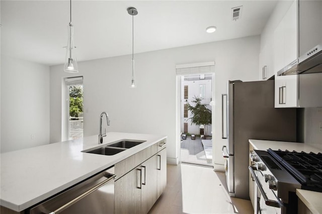 kitchen with a kitchen island with sink, a sink, visible vents, light countertops, and appliances with stainless steel finishes