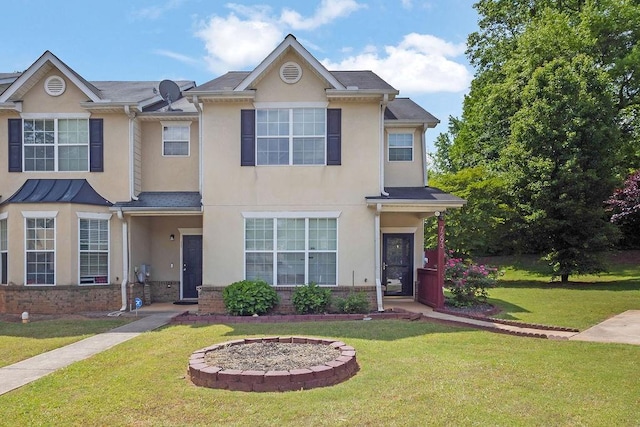 townhome / multi-family property featuring brick siding, a front lawn, and stucco siding
