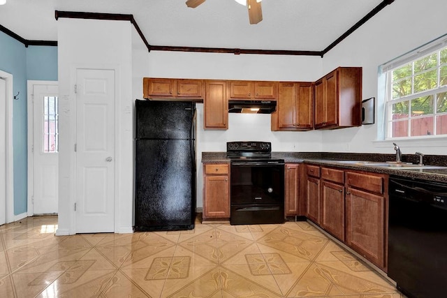 kitchen with dark countertops, a sink, black appliances, ornamental molding, and under cabinet range hood